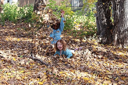 Brother and sister four-year-old Levi (standing) and two-year-old Rowa play in the leaves on Thanksgiving Day near a walking path in Brandon's west end. (Michele McDougall/The Brandon Sun)