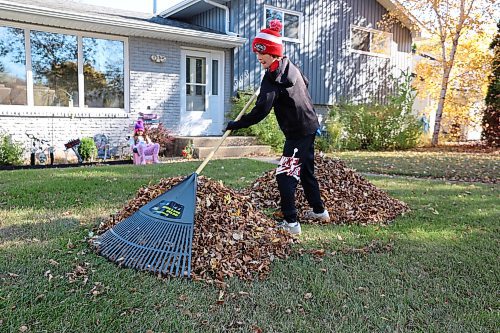 Nine-year-old Hunter Urquhart rakes the leaves in his front yard in Brandon's west end on Thanksgiving Day, while his seven-year-old sister Austin looks on. (Michele McDougall/The Brandon Sun)