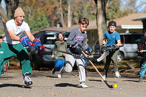 Jaxon Winter races up the road towards the net as group of kids — and kids at heart — play road hockey on a cool Thanksgiving Monday afternoon in the Valleyview area. (Thomas Friesen/The Brandon Sun)