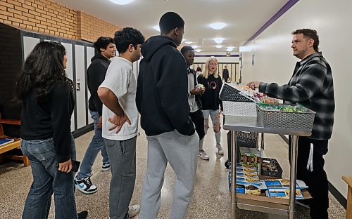 Educational assistant Cory Kukurudz hands out snacks to students at Vincent Massey High School provided by the Food for Thought program before classes started on Wednesday morning. (Colin Slark/The Brandon Sun)