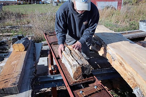 Neil Friesen demonstrates how his shingle brace works. He built the template, which allows him to cut shingles from wood blocks, and now uses it to create rooftop shingles using old hydro poles. (Connor McDowell/Brandon Sun)