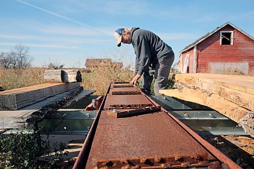 Neil Frieson demonstrates how his custom shingle brace lifts up and down to cut tapered edges. He built the device and uses it to make homemade wood shingles from old hydro poles. (Connor McDowell/Brandon Sun)