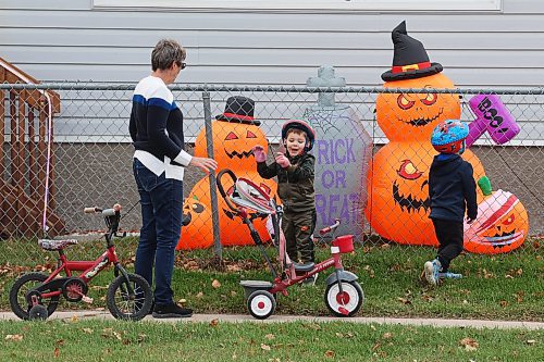 Jackie Sallows and her grandsons Thomas and Jacob Sallows check out halloween decorations while out for a walk in Minnedosa on a warm Thursday. 
(Tim Smith/The Brandon Sun)