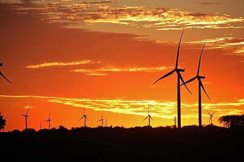 The rising sun silhouettes a pair of wind turbines against a glowing red sky at St. Joseph, Man. (Matt Goerzen/The Brandon Sun)