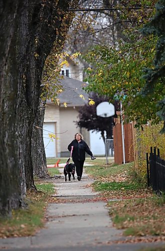 Carole Wyton walks her dog Charlie down a sidewalk along Whillier Drive on Friday afternoon. (Matt Goerzen/The Brandon Sun)