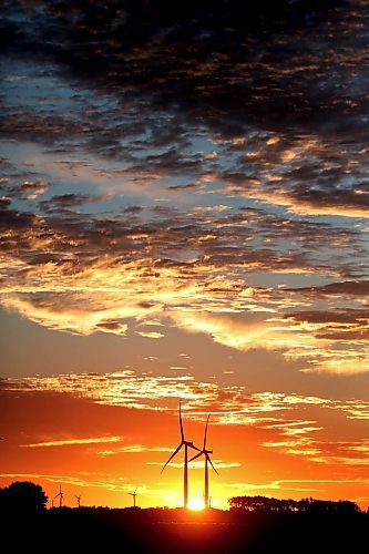 The rising sun silhouettes a pair of wind turbines at St. Joseph, MB in this file image from 2022. (Matt Goerzen/The Brandon Sun)