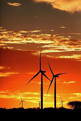 The rising sun silhouettes a pair of wind turbines against a glowing red sky at St. Joseph, MB in this file image from 2022. (Matt Goerzen/The Brandon Sun)