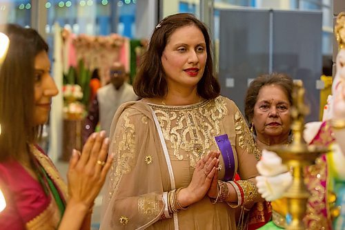 BROOK JONES/FREE PRESS
The Hindu Society of Manitoba hosts its annual Diwali Mela (Festival of Lights) at the RBC Convention Centre in Winnipeg, Man. Saturday, Oct. 19, 2024. Romona Goomansingh (middle) who is wearing a piece of Indian clothing called a anarkali salwar kameez, Bhawna Thakrar (left) who is draped in a traditional sari and Romona's mother, Mona Goomansingh (right), who is weaing a gujarati are pictured praying in front of Lord Ganesha.