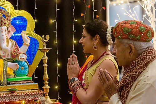 BROOK JONES/FREE PRESS
The Hindu Society of Manitoba hosts its annual Diwali Mela (Festival of Lights) at the RBC Convention Centre in Winnipeg, Man. Saturday, Oct. 19, 2024. Pictured: Shipra Verma (left) who is wearing a ghagra choli and Ganpat Lodla who is wearing a sherwani are pictured praying in front of Lord Ganesha.