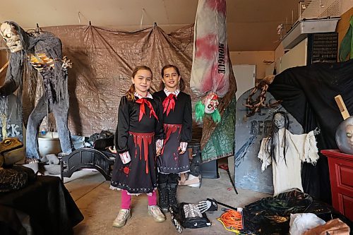 Sisters Claire and Emma Mitchell, dressed as the creepy twins from &quot;The Shining&quot; show off some of the ghastly features of their family's Cedar Hollow haunted house on Sunday afternoon. (Colin Slark/The Brandon Sun)