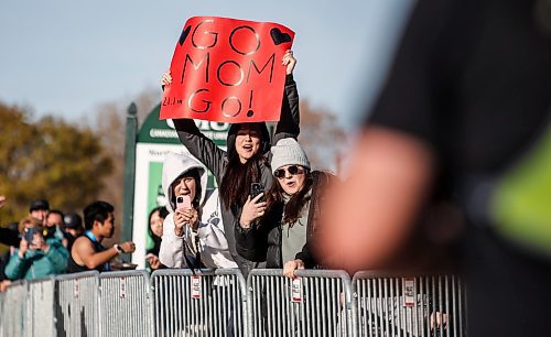 JOHN WOODS / FREE PRESS
Erica Alderson holds a sign as her sister Alyssa, right, and friend Hannah Friesen cheer on their mom Johanne Alderson as she finishes the WFPS Run at the Canadian Mennonite University Sunday, October 20, 2024. 

Reporter: s/u