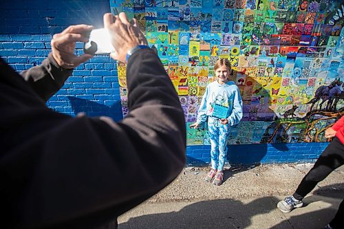 MIKAELA MACKENZIE / FREE PRESS
	
Allie Reinhardt (nine) takes a photo with her painted tile at the Canada Connects Love &amp; Family mosaic mural unveiling at 1797 Portage Avenue on Monday, Oct. 21, 2024.

For biz story.
Winnipeg Free Press 2024