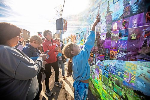 MIKAELA MACKENZIE / FREE PRESS
	
Allie Reinhardt, nine, takes a look at the Canada Connects Love &amp; Family mosaic mural at the unveiling at 1797 Portage Avenue on Monday, Oct. 21, 2024.

For biz story.
Winnipeg Free Press 2024