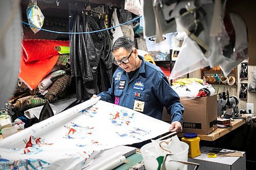 MIKAELA MACKENZIE / FREE PRESS
	
Roy Liang, the maker behind Winnipeg North of Fargo, unrolls some of his favourite fabric in his basement workshop space on Tuesday, Oct. 22, 2024.

For Eva Wasney story.
Winnipeg Free Press 2024