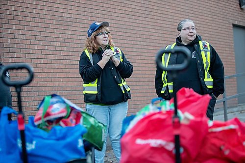 BROOK JONES/FREE PRESS
Sabu's Cubs co-founder Siobhan Faulkner (left), 64, gives instructions to volunteers as she stands in front of wagons full of food, bottle water and essential items such as socks before they head out on their weekly community walk in North Point Douglas in Winnipeg, Man., Wednesday, Oct. 23, 2024. Also pictured is Caitlin Rhoda (right), 36, who is also a co-founder of the group along with Heather Nyman, 49.