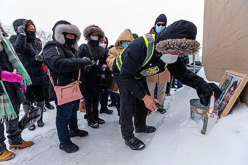 Daniel Crump / Winnipeg Free Press. People place candles and flowers near the pick up window where John Lloyd Barrion worked. Barrion was killed while working at the beer vendor attached to the Travelodge on Notre Dame Ave. February 19, 2022.