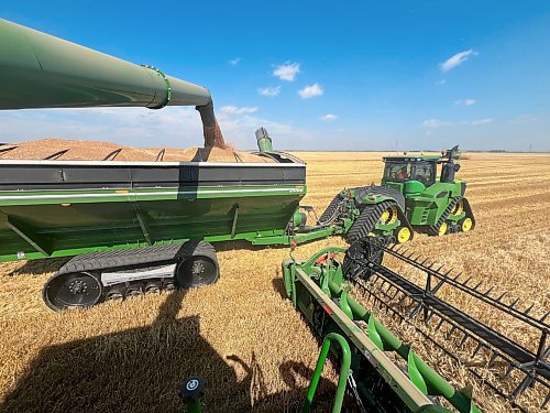 A full hopper of wheat is unloaded from a combine on an 80-acre wheat field owned by Hillside Hutterite Colony on Wednesday afternoon. (Matt Goerzen/The Brandon Sun)