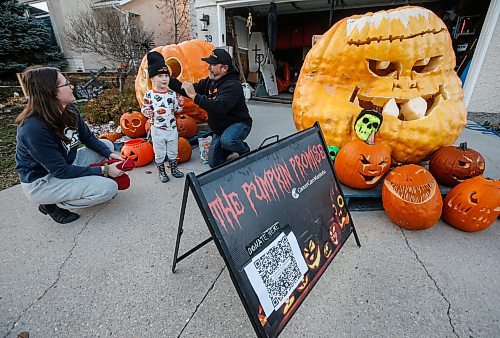 JOHN WOODS / FREE PRESS
Chris Okell, who for years has been decorating donated pumpkins outside his St. Vital home to raise funds for CancerCare Manitoba, talks with his neighbours Jenn and Dimitri Ilic as he sets up his display on his driveway Monday October 28, 2024. Okell was motivated to make and start his Pumpkin Promise charity when his mother Marietta died of pancreatic cancer in 2010.

Reporter: massimo