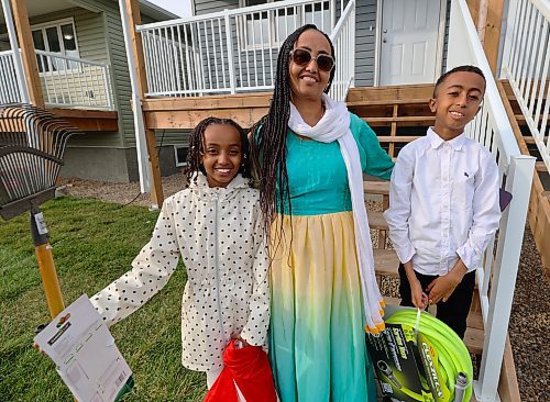 Samira and her two children, 11-year-old Jerusalem (left) and 10-year-old Jonathan, stand in front of their new Habitat for Humanity duplex on Franklin Street after receiving the key during an official key ceremony. (Photos by Michele McDougall/The Brandon Sun)