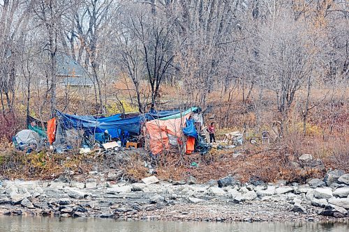 MIKE DEAL / FREE PRESS
A person stands outside an encampment at the foot of the CNR Main Line Bridge Tuesday morning.
241029 - Tuesday, October 29, 2024.