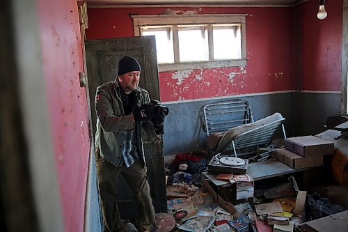 Albert Roy steps over junk covering the floor of an abandoned home in the rural municipality of Oakview. Roy has made a hobby of photographing delapidated buildings for a Facebook group called &quot;Rustic Relics Manitoba&quot;. (Connor McDowell/Brandon Sun)