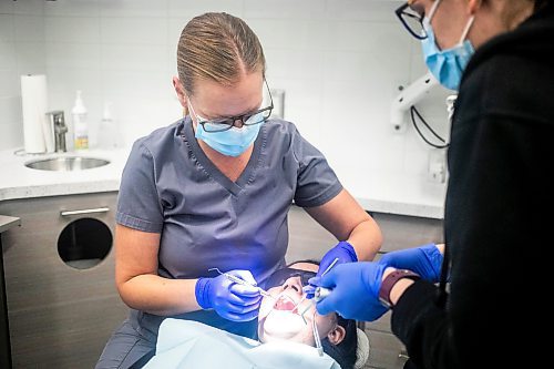 MIKAELA MACKENZIE / FREE PRESS
	
Dentist Carolyn Roberston (left) and dental assistant Kaylen Wallbridge demonstrate their craft on administrator Mameet Kaur at Harte Dental on Thursday, Oct. 10, 2024.

For AV story.
Winnipeg Free Press 2024