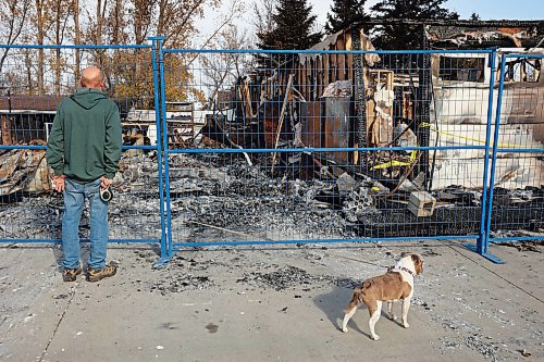 31102024
Lawrence Medd and his french bulldog Lola walk past the duplex his father Bill Medd lived in on Thursday. Lawrence is visiting his dad in Killarney from Alberta. Lola woke them in the night Sunday as Bill&#x2019;s duplex went up in flames. The duplex on Finlay Street was completely destroyed in the fire but the Medd&#x2019;s and the duplex&#x2019;s other resident all escaped the blaze. 
(Tim Smith/The Brandon Sun)