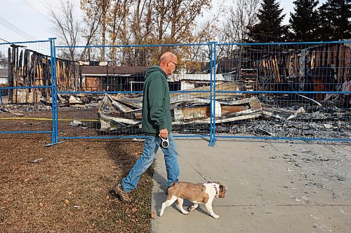 31102024
Lawrence Medd and his french bulldog Lola walk past the duplex his father Bill Medd lived in on Thursday. Lawrence is visiting his dad in Killarney from Alberta. Lola woke them in the night Sunday as Bill&#x2019;s duplex went up in flames. The duplex on Finlay Street was completely destroyed in the fire but the Medd&#x2019;s and the duplex&#x2019;s other resident all escaped the blaze. 
(Tim Smith/The Brandon Sun)