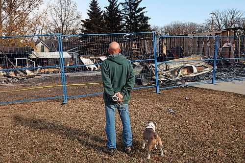 31102024
Lawrence Medd and his french bulldog Lola walk past the duplex his father Bill Medd lived in on Thursday. Lawrence is visiting his dad in Killarney from Alberta. Lola woke them in the night Sunday as Bill&#x2019;s duplex went up in flames. The duplex on Finlay Street was completely destroyed in the fire but the Medd&#x2019;s and the duplex&#x2019;s other resident all escaped the blaze. 
(Tim Smith/The Brandon Sun)