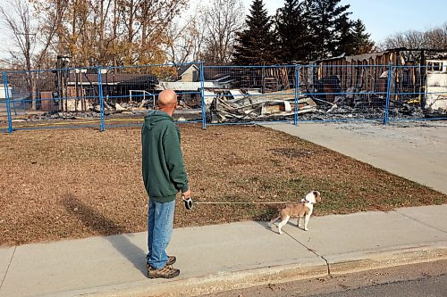 31102024
Lawrence Medd and his french bulldog Lola walk past the duplex his father Bill Medd lived in on Thursday. Lawrence is visiting his dad in Killarney from Alberta. Lola woke them in the night Sunday as Bill&#x2019;s duplex went up in flames. The duplex on Finlay Street was completely destroyed in the fire but the Medd&#x2019;s and the duplex&#x2019;s other resident all escaped the blaze. 
(Tim Smith/The Brandon Sun)