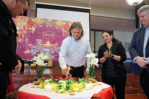 Brandon Mayor Jeff Fawcett lights a candle as part of Diwali celebrations at Brandon City Hall with members of the Wheat City’s Hindu community on Friday. Diwali celebrations started Thursday evening. The community is holding a big celebration on Nov. 9 at the Keystone Centre’s UCT Pavilion. The Disco Diwali 2024 event will feature music, food and dance. (Tim Smith/The Brandon Sun)