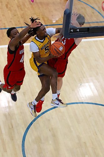 Dewayne Thompson tries a tough layup against a pair of Wesmen defenders. (Thomas Friesen/The Brandon Sun)