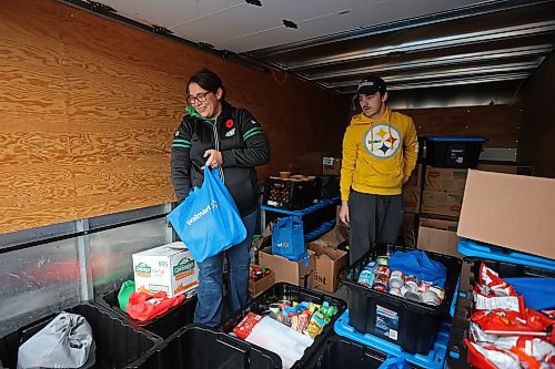 Carla Mitchell with the Cedar Hollow haunted house on Cedar Bay in Brandon helps Tytan Durgan with Samaritan House Ministries load nonperishable foods and other donated items into the back of a Samaritan House truck on Monday morning after visitors to the haunted house donated more than 1,500 items for the food bank along with approximately $300. The Samaritan House Ministries food bank sees demand for approximately 100 hampers per day and up to 150 hampers on busier days. The total number of hampers distributed in 2023 was around 35,000. (Tim Smith/The Brandon Sun)