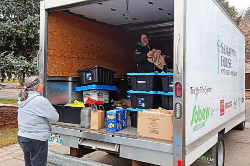 04112024
Marcia Wiebe, food bank coordinator at Samaritan House Ministries' loads nonperishable foods and other donated items into the back of a Samaritan House truck with Carla Mitchell of Cedar Hollow haunted house on Cedar Bay in Brandon on Monday morning after visitors to the haunted house donated over 1500 items for the food bank along with approximately $300. The Samaritan House Ministries food bank sees demand for approximately 100 hampers per day and up to 150 hampers on busier days. The total number of hampers distributed in 2023 was around 35,000. (Tim Smith/The Brandon Sun)