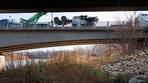 MIKE DEAL / FREE PRESS
Workers trying to haul a tractor-trailer out of a ditch adjacent to a Trans-Canada Highway bridge over the Assiniboine River near St. Fran&#xe7;ois Xavier west of Winnipeg Thursday afternoon after a collision occurred Wednesday.
241107 - Thursday, November 07, 2024.