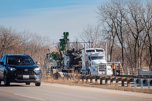 MIKE DEAL / FREE PRESS
Workers trying to haul a tractor-trailer out of a ditch adjacent to a Trans-Canada Highway bridge over the Assiniboine River near St. Fran&#xe7;ois Xavier west of Winnipeg Thursday afternoon after a collision occurred Wednesday.
241107 - Thursday, November 07, 2024.