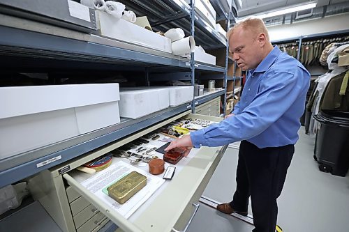 RCA Museum director Andrew Oakden opens a storage cabinet holding various items in the museum's collection that a typical soldier on the front lines in the First World War that were given by the military. The museum has an extensive collection of war memorabilia both on display and in its archival room, including uniforms, photos, pins, weapons and other paraphernalia. (Matt Goerzen/The Brandon Sun)