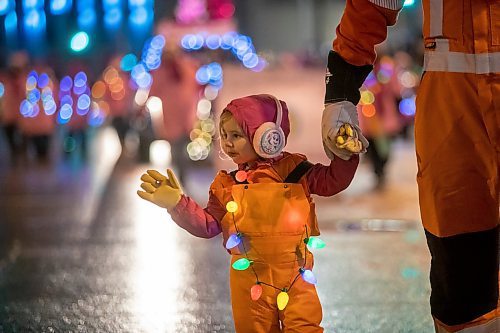 BROOK JONES/FREE PRESS
Two-year-old Raemi Weremiuk waves to the crowd as she holds her dad's hand. Raemi's dad is Brett Weremiuk and the father-daughter duo were participating with the Manitoba Hydro entry in the Manitoba Hydro Santa Claus Parade in Winnipeg, Man., Saturday, Nov. 16, 2024. The Santa Claus parade has run annually in Winnipeg since the former Eaton&#x2019;s department store organized the first one in 1909.