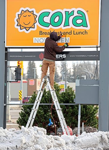 18112024
Travis Loewen with Off The Wall Signs puts up Now Open decals on the Cora sign on 18th St. on Monday.
(Tim Smith/The Brandon Sun)