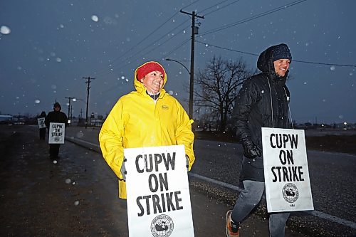 19112024
Gabriela Azure and Pierre Erickson-Smith picket outside Canada Post&#x2019;s Brandon mail processing plant on Douglas Street along with fellow striking Canada Post letter carriers as snow falls late Tuesday afternoon. Approximately 55,000 postal workers represented by the Canadian Union of Postal Workers went on strike across Canada on Friday.
(Tim Smith/The Brandon Sun)