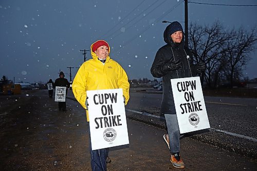 19112024
Gabriela Azure and Pierre Erickson-Smith picket outside Canada Post&#x2019;s Brandon mail processing plant on Douglas Street along with fellow striking Canada Post letter carriers as snow falls late Tuesday afternoon. Approximately 55,000 postal workers represented by the Canadian Union of Postal Workers went on strike across Canada on Friday.
(Tim Smith/The Brandon Sun)