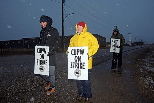 19112024
Pierre Erickson-Smith and Gabriela Azure picket outside Canada Post&#x2019;s Brandon mail processing plant on Douglas Street along with fellow striking Canada Post letter carriers as snow falls late Tuesday afternoon. Approximately 55,000 postal workers represented by the Canadian Union of Postal Workers went on strike across Canada on Friday.
(Tim Smith/The Brandon Sun)