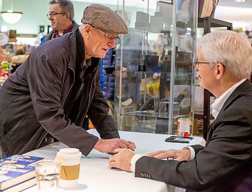 BROOK JONES/FREE PRESS
McNally Robinson hosts a special evening with Marc Garneau featuring a conversation hosted by Free Press Editor Paul Samyn in Winnipeg, Man., Wednesday, Nov. 20, 2024. Pictured: Canada's first man in space Garneau (right) autographs a copy of his memoir A Most Extraordinary Ride: Space, Politics, and the Pursuit of a Canadian Dream for Winnipeg resident Ted Scoles..