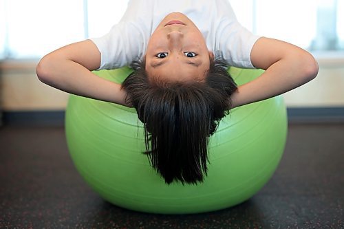 École New Era School Grade 5 student Jaxon Ferland stretches on an exercise ball at the YMCA of Brandon during a YMCA Enrichment Program noon-hour workout with other New Era students on Thursday. The pilot program currently involves eight students from New Era ranging from grades 2-8 and is meant for students who benefit from more movement and activity throughout their school day. New Era counsellor Karl McDaniel and French immersion teachers Louise Roberts and Ellen Murray accompany the students to the YMCA three days a week and go through workouts with the kids. See story on Page A3. (Tim Smith/The Brandon Sun)