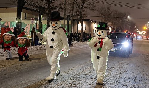 Two snowmen walk along Princess Avenue during the 2024 Brandon Santa Parade Saturday evening. (Michele McDougall/The Brandon Sun) 
