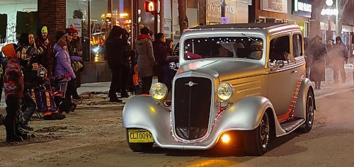 A collectible car decked out in Christmas lights takes part in the 2024 Brandon Santa Parade Saturday evening with the route going down Rosser and then Princess Avenues. (Michele McDougall/The Brandon Sun) 