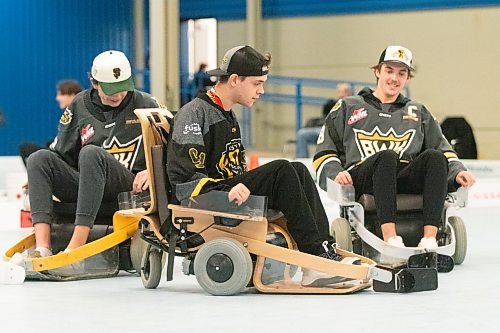 Zander Wallin navigates his cart between Roger McQueen and Quinn Mantei of the Brandon Wheat Kings in Westman Volt hockey at the Keystone City Centre Sqaure arena. (Matt Packwood/The Brandon Sun)