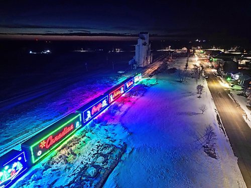 The brightly lit CPKC Holiday Train pauses in Newdale while making its way to Shoal Lake for an evening stop and performance by the Anyway Gang in 2023. (FILE/The Brandon Sun)