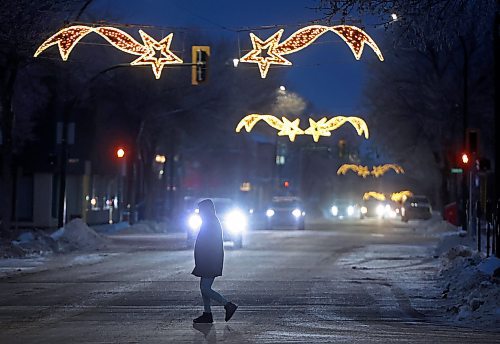 26112024
A pedestrian makes their way across Princess Avenue in downtown Brandon at dusk as the Christmas lights above the avenue glow on Tuesday.
(Tim Smith/The Brandon Sun)