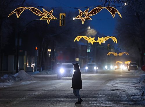 26112024
A pedestrian makes their way across Princess Avenue in downtown Brandon at dusk as the Christmas lights above the avenue glow on Tuesday.
(Tim Smith/The Brandon Sun)